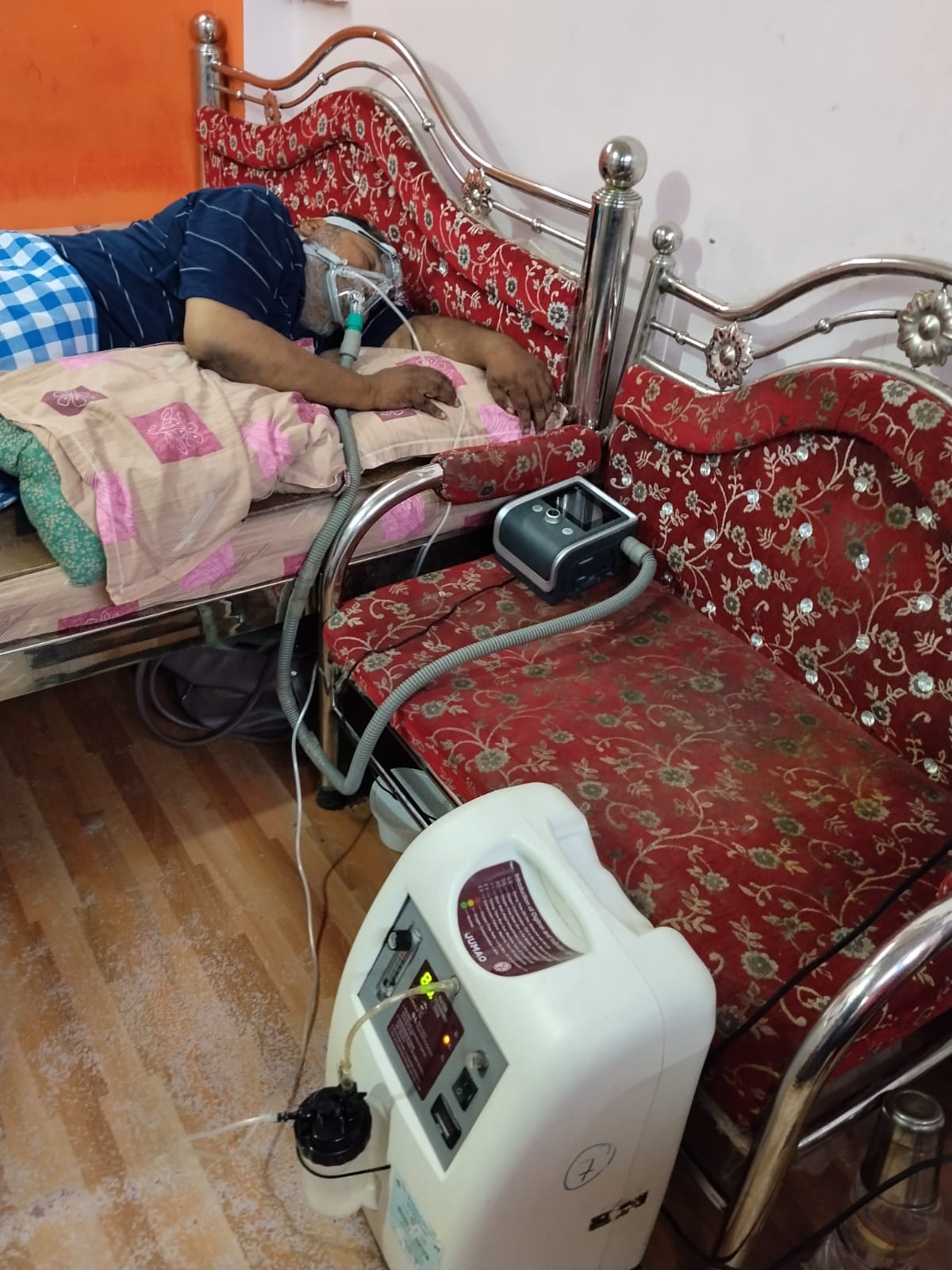 Patient receiving home respiratory support with BiPAP and oxygen equipment